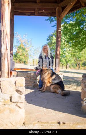 A woman takes a German Shepherd dog for a walk in nature Stock Photo