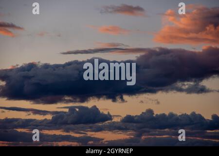 Fiery orange sunset sky and dramatic dark cumulus clouds, evening sky. Beautiful perfect sky for your photos. Heavenly background to overlay Stock Photo