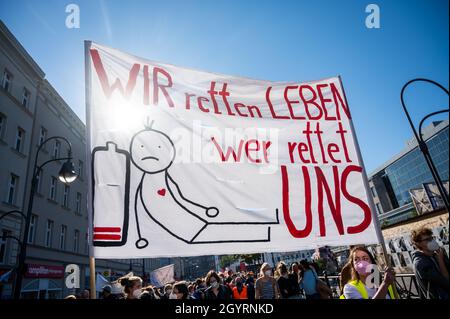 Berlin, Germany. 09th Oct, 2021. Participants carry banners and posters during a demonstration of the Berlin Hospital Movement under the motto 'We help you - who saves us?' Banners and placards, including one reading 'We save lives - who saves us'. According to a Verdi spokeswoman, more than 2000 people demonstrated in Neukölln for more staff and better working conditions in Berlin hospitals. Credit: Christophe Gateau/dpa/Alamy Live News Stock Photo