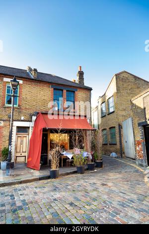 Charming cobblestone alley and Jones Dairy Cafe on Ezra Street, Bathnal Green, London, UK Stock Photo