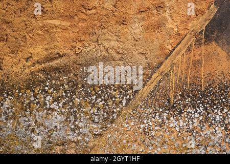 Mouldy ochre colored cement plaster wall with damp, grunge background or texture Stock Photo