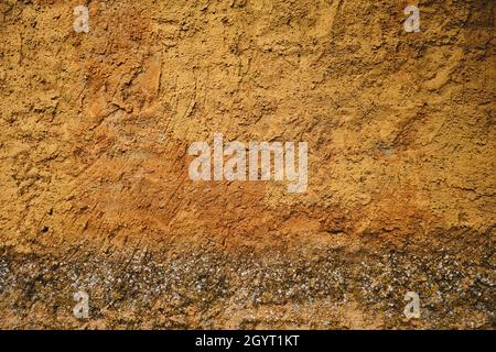 Ochre colored cement plaster coating wall with damp, grungy rustic background or texture Stock Photo