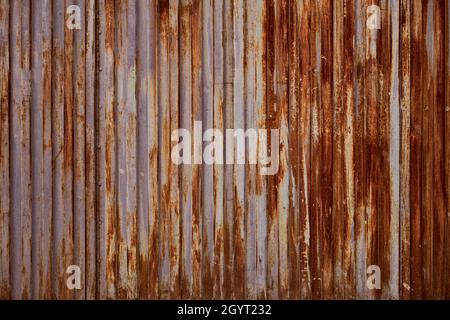 Old rusty metallic shutter with worn out peeling paint, grunge background or texture Stock Photo