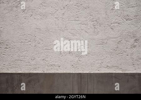 White traditional limewash plaster wall with gray grungy ceramic tile skirting board, architecture detail background Stock Photo
