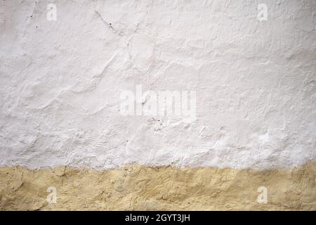 Old whitewashed lime wall with yellow skirting board, traditional architecture in La Mancha, Spain Stock Photo