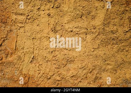 Ochre colored cement plaster coating wall rough texture detail Stock Photo
