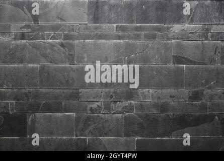 Dark gray stone tiled wall facing, ceramic stoneware, matt finish, modern architecture grunge background or texture Stock Photo