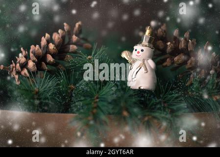 snowman and two cones. Christmas snowy background. Stock Photo