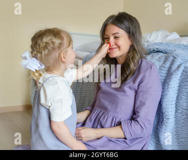 Baby boy playing with magnetic construction toy while sitting on bed Stock Photo