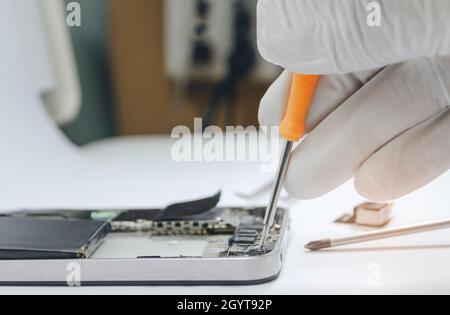 Phone motherboard or Fixing repairs into the motherboard for smartphone in lab By professional technician on desk. Stock Photo