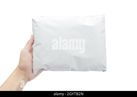 Hand holding blank white plastic bag package mockup template isolated on white background with clipping path. Stock Photo