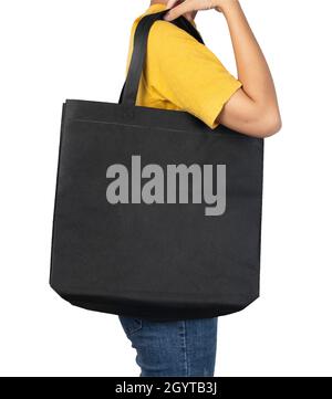 Woman holding blank black fabric canvas bag isolated on white background with clipping path, eco concept. Stock Photo