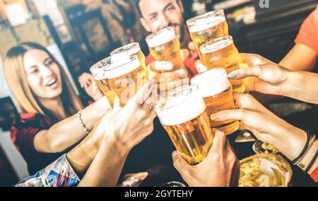 Friends drinking beer at brewery bar restaurant on weekend - Friendship concept with young people having fun together toasting brew pint on happy hour Stock Photo