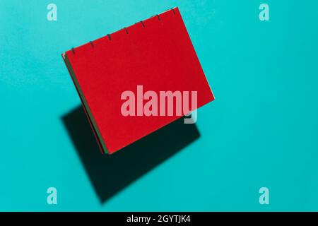 Red book isolated floating clean in front of blue background with copy space for text Stock Photo