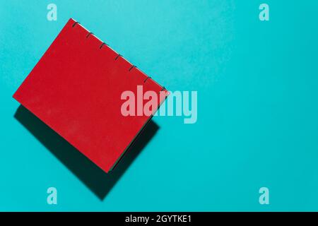 Red book floating in front of blue background with copy space for text Stock Photo