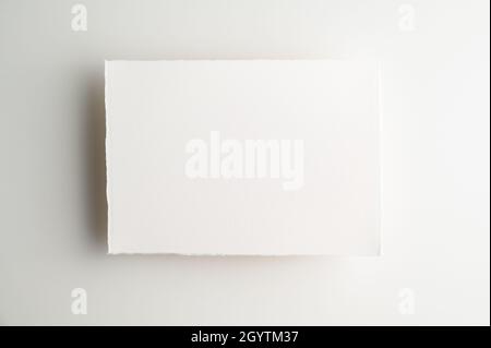 Blank backdrop for notes, to-do lists, messages, reminders, notices or notepapers. Blank sheet of white handmade paper on light background. Stock Photo