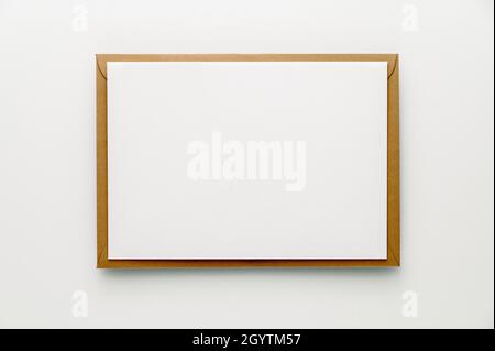 Blank greeting card, letter or stationery mockup: White sheet of handmade paper and a brown envelope on white background. Stock Photo