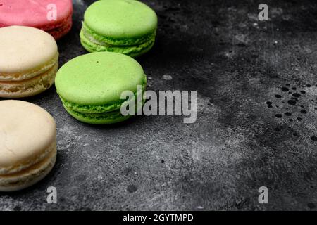 Sweet colorful macarons set, on black dark stone table background, with copy space for text Stock Photo