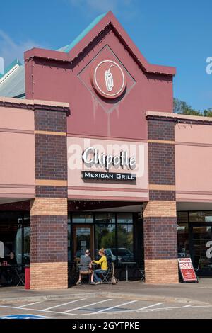 Vadnais Heights, Minnesota.  Couple eating outside on patio at Chipotle Mexican Grill with a now hiring sign. It is an American chain of fast casual r Stock Photo