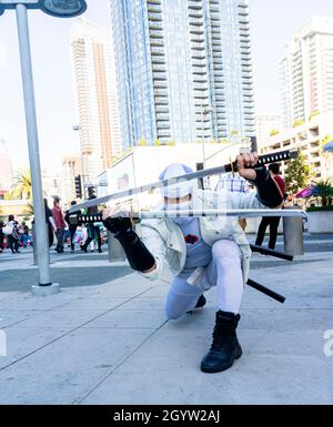 Attendee cosplayer portraying Japanese thug warrior ninja in white clothing with head cover and two katanas at Comic Con in Los Angeles Stock Photo