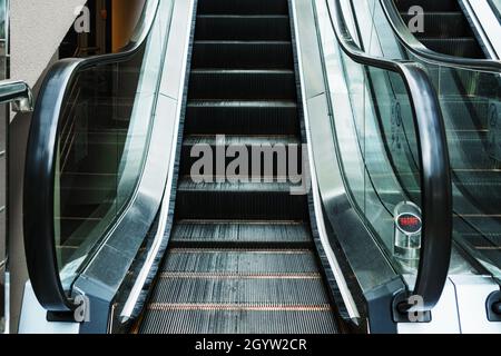 Escalator lifting steps in the waiting rooms of the station. Climbing the stairs. electric escalator Stock Photo