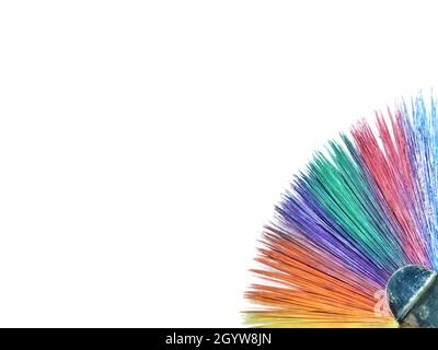 Close-up of a paintbrush painted in rainbow colors on a white canvas background. Stock Photo