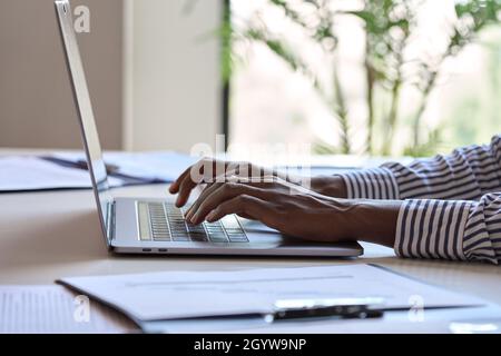 Young African black female hands typing on laptop computer keyboard. Stock Photo