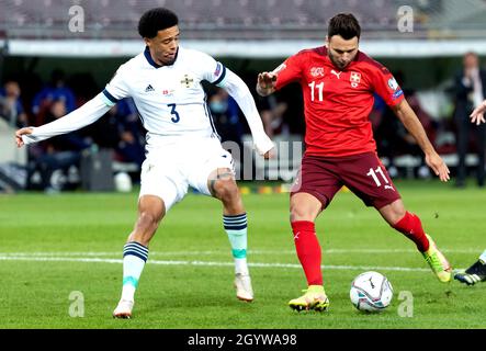 Northern Ireland's Jamal Lewis (left) and Switzerland's Renato Steffen battle for the ball during the FIFA World Cup Qualifying match at Stade de Geneve, Switzerland. Picture date: Saturday October 9, 2021. Stock Photo