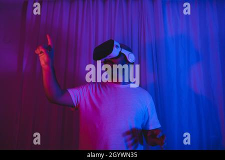 young man using vr glasses in his room. Stock Photo