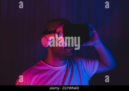 A young man who discovers new worlds by wearing augmented reality glasses for the world of the metaverse. Stock Photo
