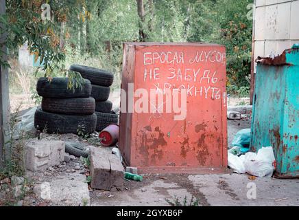 metal box with note in russian throwing rubbish don't forget to grunt on the background of garbage Stock Photo