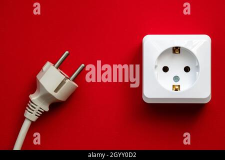 white socket and black plug isolated on red background Stock Photo