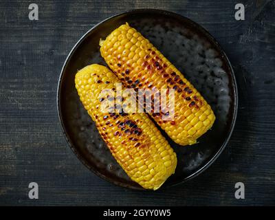 grilled corn on black plate, top view Stock Photo