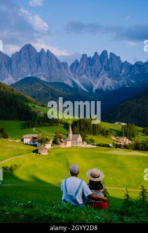 couple viewing the landscape of Santa Maddalena Village in Dolomites Italy, Santa Magdalena village magical Dolomites mountains, Val di Funes valley, Trentino Alto Adige region, South Tyrol, Italy,  Stock Photo