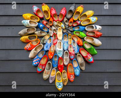 Netherlands. Rough background from gray boards. Many national Dutch Klomp shoes are laid out in the shape of a heart Stock Photo