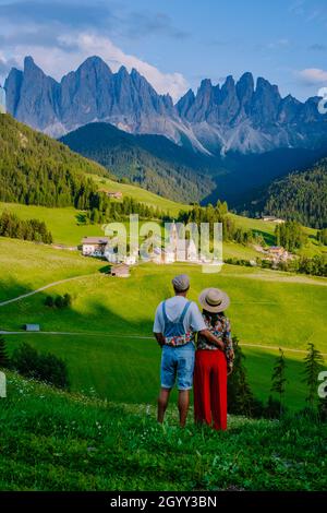 couple viewing the landscape of Santa Maddalena Village in Dolomites Italy, Santa Magdalena village magical Dolomites mountains, Val di Funes valley, Trentino Alto Adige region, South Tyrol, Italy,  Stock Photo