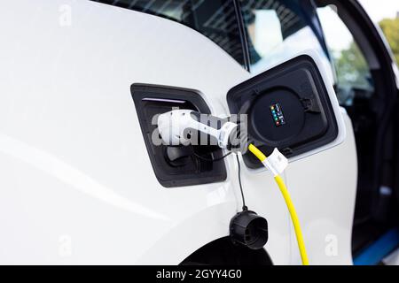 Gateshead UK: 26th Sept 2021: A hand-held closeup of an electric car on charge (EV, green sustainable travel) Stock Photo