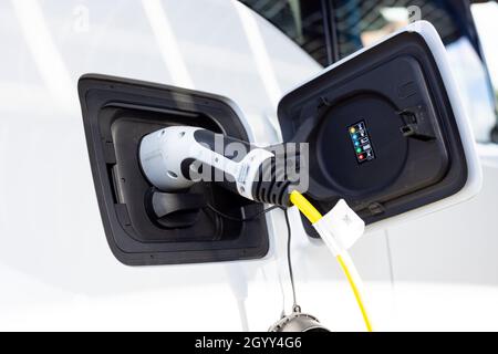Gateshead UK: 26th Sept 2021: A hand-held closeup of an electric car on charge (EV, green sustainable travel) Stock Photo
