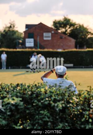 Lawn bowls players / bowlers in whites at a summer evening tournament  game in rural England Britain UK - British summer bowling green club Stock Photo