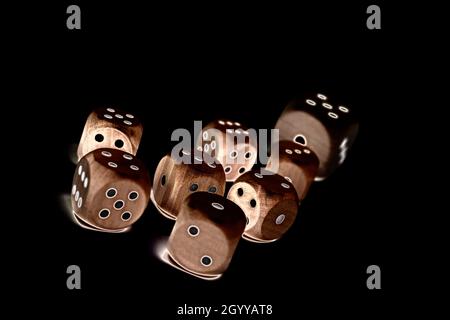 Wooden game dice against a black background Stock Photo