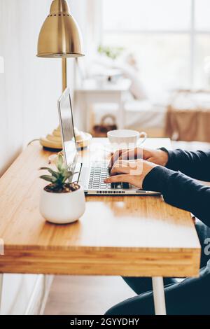 Businessman working on laptop at home office. Man watching online webinar. Remote studying or work concept Stock Photo