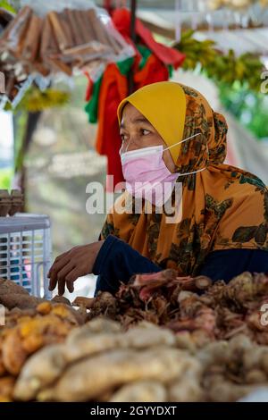 Kuala Lumpur, Malaysia - September 18, 2021 Woman seller wearing face mask at the local ingredients fresh food stall. Stock Photo