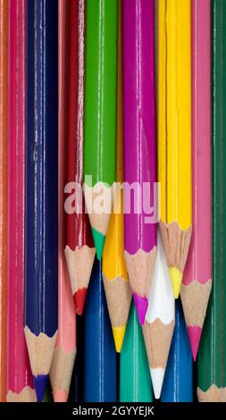 vertical shot of stationary wooden color pencils arranged straight in layers Stock Photo