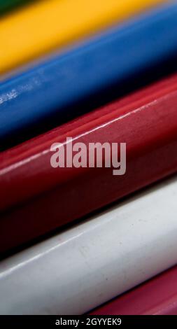 vertical macro shot of the bodies of a variety of wooden color pencils arranged in layers Stock Photo