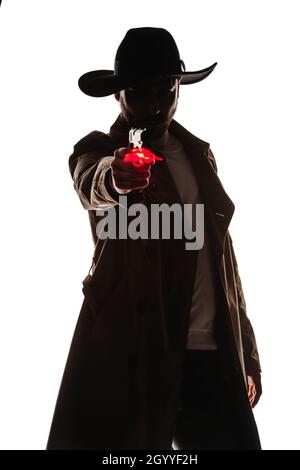 Good looking young man dressed in stylish sheriff outfit pointing a handgun Stock Photo