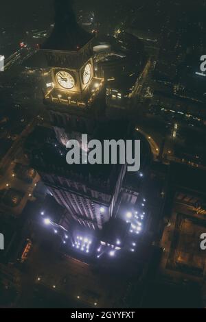 Notable high-rise building Palace of Culture and Science covered in fog, lit by colored lights, night city aerial panorama Stock Photo