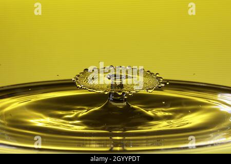Drops of water on a surface of water that lead to waves and water sculptures. Stock Photo