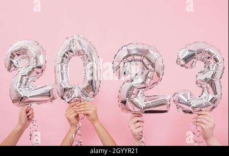 Happy New year 2023 celebration. Silver foil balloons numeral 2023 on a pink background. Stock Photo
