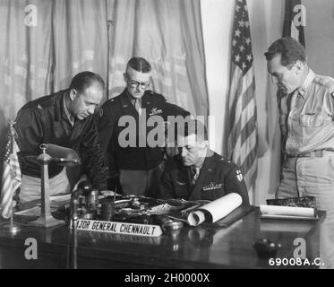 Major Gen. Claire Chennault of the US Air Force (seated) studies aerial maps of Southern China as fellow officers look on. Stock Photo