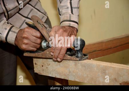 A closeup shot of a carpenter using a block plane to cut and smooth wood Stock Photo
